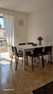 a dining room table with chairs and a vase of flowers at Apartment Rivarela BLU - newly renovated and top location near sea in Novigrad Istria