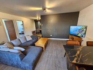 uma sala de estar com um sofá e uma televisão de ecrã plano em entire 2 bed Apartment Jasmine fully serviced em Elmers End
