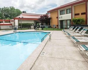 a swimming pool with lounge chairs and a building at Quality Inn & Suites Kansas City I-435N Near Sports Complex in Kansas City