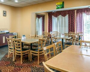 a dining room with wooden tables and chairs at Quality Inn & Suites Kansas City I-435N Near Sports Complex in Kansas City