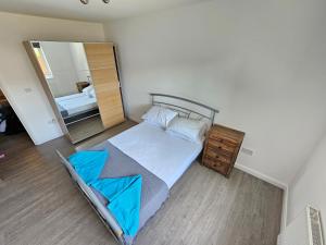 a bedroom with a bed and a large mirror at entire 2 bed Apartment Jasmine fully serviced in Elmers End