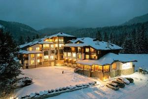 a large building in the snow with cars parked at Secret Lake 533 at Oak Residence in Smolyan