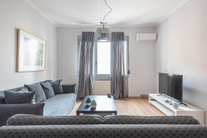 un soggiorno con un divano e una TV di Syntagma SQ Residence ad Atene