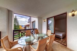 d'une salle à manger avec une table en verre et des chaises sur un balcon. dans l'établissement Secret Lake 533 at Oak Residence, à Smolyan