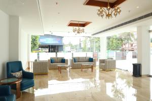 una hall con divani, tavoli e lampadario a braccio di Hotel Seven Lights a Ernakulam