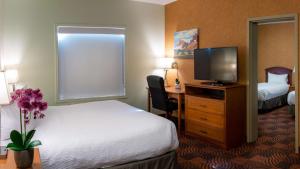 Postel nebo postele na pokoji v ubytování Service Plus Inns and Suites Calgary
