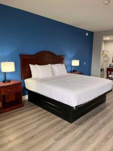 um quarto com uma cama grande e uma parede azul em SureStay by Best Western McAlester em McAlester
