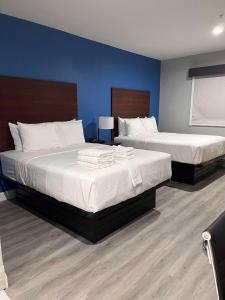 Duas camas num quarto com paredes azuis em SureStay by Best Western McAlester em McAlester