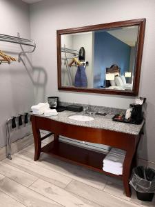 La salle de bains est pourvue d'un lavabo et d'un miroir. dans l'établissement SureStay by Best Western McAlester, à McAlester