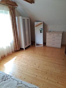 an empty room with a refrigerator and a dresser at Apartamentai Tigro guolis Rusnėje in Rusnė +9 photos