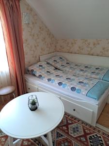 a small room with a bed and a table at Apartamentai Tigro guolis Rusnėje in Rusnė
