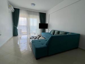 a living room with a blue couch and a television at PARADISE APARTMENT in Sarandë