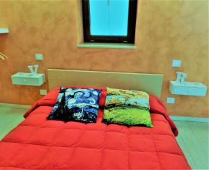 a bedroom with a bed with a red comforter and a window at Regina Viarum Apartment, Historic City Centre in Brindisi