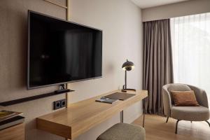 a hotel room with a large flat screen tv on the wall at ATLANTIC Hotel Heidelberg in Heidelberg