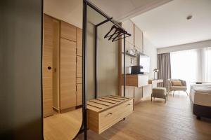 Habitación con espejo y dormitorio con cama. en ATLANTIC Hotel Heidelberg en Heidelberg