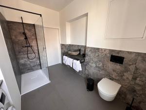 y baño con ducha y aseo. en Rilke Apartments en Linz