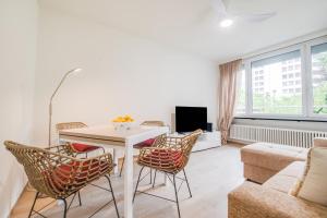 RELAX Camelia Apartment في لوكارنو: غرفة معيشة مع طاولة وكراسي وأريكة