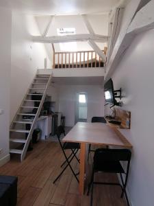 Pokój z drewnianym stołem i schodami w obiekcie Studio plein de charme - 2 w Orleanie
