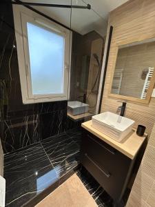 La salle de bains est pourvue d'un lavabo et d'un miroir. dans l'établissement T4 jolie vue avec jaccuzzi, à Vitrolles