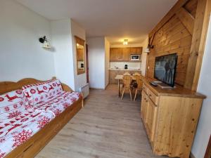 a bedroom with a bed and a flat screen tv at Les Alpages du Corbier C101 in Villarembert