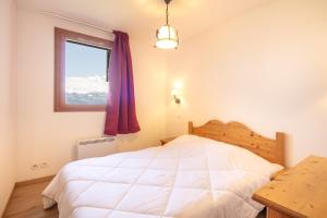 a bedroom with a white bed and a window at Les Alpages du Corbier C101 in Villarembert +13 photos