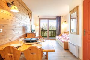 a dining room with a table and a couch at Les Alpages du Corbier C101 in Villarembert