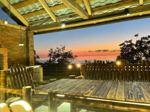 a wooden table and chairs on a patio with a sunset at SUNSET BUKNARI in Buknari +8 photos