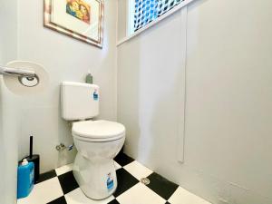 une salle de bain avec toilettes et un sol à carreaux noirs et blancs dans l'établissement Barton Cottage, à Katoomba 80 autres photos