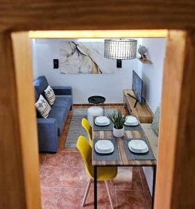 sala de estar con mesa y sillas amarillas en El Rincón de Mariela by Travel Home, en Segura de la Sierra