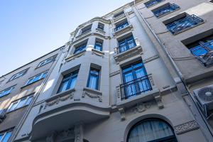 un edificio alto de color blanco con ventanas azules en Alness Residence en Estambul