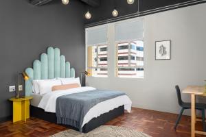 a bedroom with a bed with a blue headboard at BlackBrick Cape Town Foreshore in Cape Town