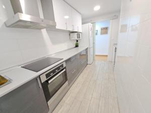 Il comprend une cuisine avec des appareils électroménagers blancs et du parquet. dans l'établissement Céntrico apartamento en Valencia próximo parada de metro Ángel Guimerà, à Valence