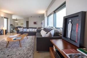 a living room with a couch and a tv at Sounio Villa Poseidon Temple View in Sounio