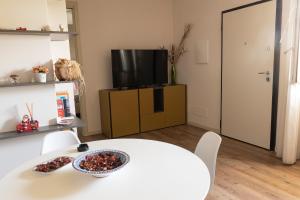 salon z białym stołem i telewizorem w obiekcie La Dimora Del Bue w mieście Matera