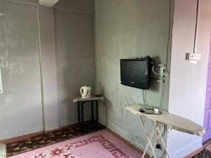 En TV eller et underholdningssystem på OYO 90797 Napoh Motel