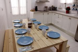 a wooden table in a kitchen with blue dishes on it at Casa de la Alegría in Granada