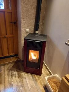 a wood burning stove in a room with a door at Casita con encanto tranquilidad VILLAVIEJA DEL LOZOYA Wi-Fi No fumador EN SIERRA DE MADRID Y A 40 M DE CAPITAL in Villavieja del Lozoya