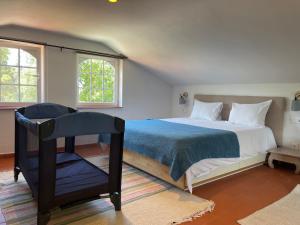 Un dormitorio con una cama grande y una silla. en A House in The Woods, en Sintra 70 fotos más