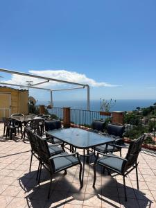 um pátio com mesas e cadeiras e o oceano em Casa Vittoria em Vietri