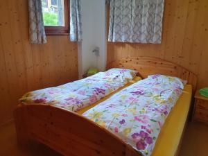 two beds in a room with wooden walls at Gadä 2 in Reckingen - Gluringen