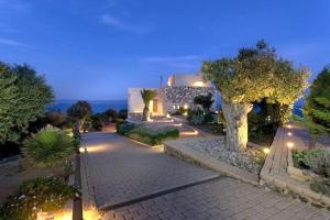 a building with lights on a walkway in front at Sounio Villa Poseidon Temple View in Sounio