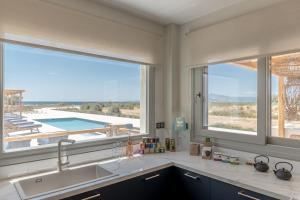 uma cozinha com uma grande janela com vista para uma piscina em Villa Armelina em Plaka