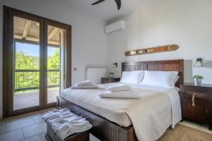 a bedroom with a large bed with towels on it at Villa Vicanti in Mesokhórion