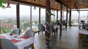 een restaurant met tafels en stoelen en grote ramen bij Nisa Wellness Retreat in Abuja