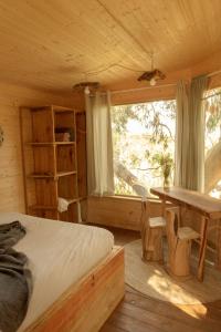 a bedroom with a bed and a table and a window at Soul Farm Algarve - Glamping & Farm Houses in Aljezur