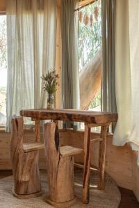 una mesa de madera y sillas en una habitación con ventana en Soul Farm Algarve - Glamping & Farm Houses, en Aljezur
