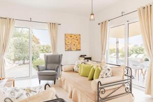 una sala de estar con un sofá y una silla en Villa Thea, en Afantou