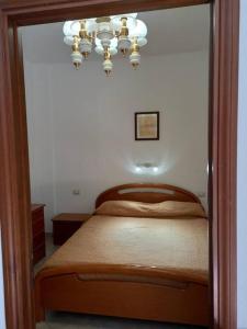 sypialnia z łóżkiem i żyrandolem w obiekcie Domus Shardana w mieście Gonnesa