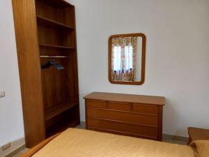 a bedroom with a bed and a dresser and a mirror at Domus Shardana in Gonnesa