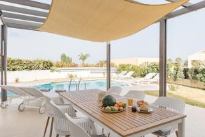 a table with a bowl of fruit sitting on a patio at Villa Thea in Afantou